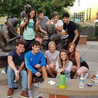 Nursing students pose for the camera by the Jesus Among Us statue